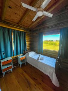 a bedroom with a large bed with a large window at La Escapada, cabaña en San Miguel del Monte in San Miguel del Monte