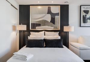 um quarto com uma cama e uma cabeceira em preto e branco em Westview Luxury Suites em Ottawa