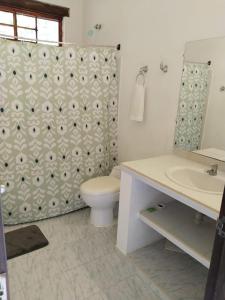 a bathroom with a toilet and a shower curtain at La Esthera Hospedaje Rural in Carmen de Apicalá