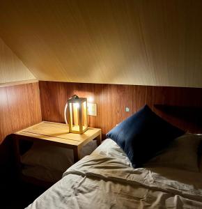 a bedroom with a bed and a table with a lamp at Dạ Khê Hill in Hue