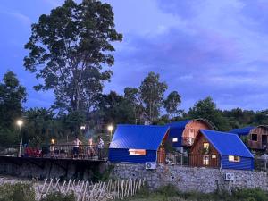 a house with a blue roof and people on a bridge at Dạ Khê Hill in Hue +1 photo