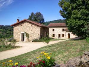 een oud stenen huis met een tuin en bloemen bij Gîte Les Salles, 4 pièces, 6 personnes - FR-1-496-61 in Les Salles