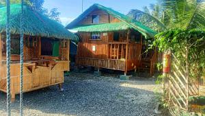 kilka drewnianych domków siedzących obok siebie w obiekcie Moalboal Bamboo House / Rooms w mieście Moalboal
