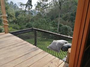 a bird cage on the deck of a house at Glamping Villa del Bosque in Santa Rosa de Cabal