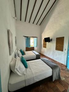 sypialnia z 2 łóżkami i telewizorem w obiekcie Altagracia w mieście San Gil