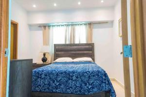 um quarto com uma cama com um cobertor azul e uma janela em Apartment Santo Domingo-Piantini em Santo Domingo