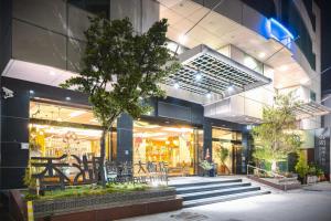 a store front of a building with a tree in front at Shianghu Boutique Hotel in Chiayi City