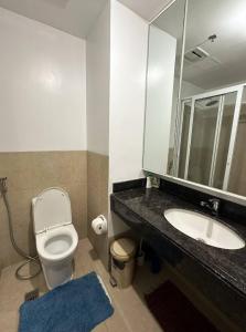 y baño con lavabo, aseo y espejo. en Unit N103 Outlook Ridge Residences, en Baguio