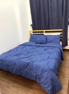 1 dormitorio con cama azul y almohadas azules en Unit N103 Outlook Ridge Residences, en Baguio