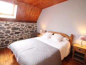 a bedroom with a bed with a stone wall at Gîte Paulhac, 6 pièces, 12 personnes - FR-1-742-420 in Paulhac