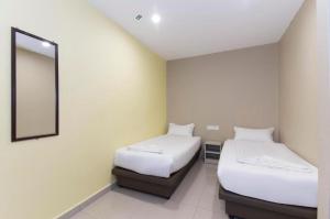 A bed or beds in a room at NEW D SOHO HOTEL GOMBAK
