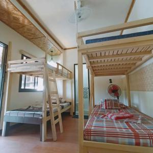a bedroom with two bunk beds in a room at El Gordo's Seaside Adventure Lodge in El Nido