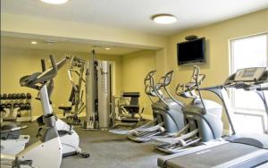 a gym with several tread machines and a flat screen tv at 3-Bedroom Luxury Condo in the Heart of the City in Salt Lake City