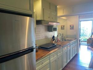 a kitchen with a refrigerator and a wooden counter top at Private and Quiet Guest Apt in Hawaii Cloud Forest in Kailua-Kona