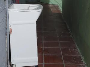 eine weiße Toilette in einem Badezimmer mit Ziegelboden in der Unterkunft Casa na Praia da Cal - Torres in Torres + 1 Foto