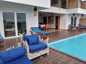 uma villa com uma piscina e cadeiras azuis em La Résidence Tiako em Ambondrona