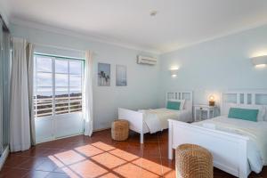TAC - Serene Shores - Portimão في Vau: غرفة نوم بيضاء مع سريرين ونافذة