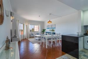 TAC - Serene Shores - Portimão في Vau: مطبخ وغرفة طعام مع طاولة وكراسي +24 صورة