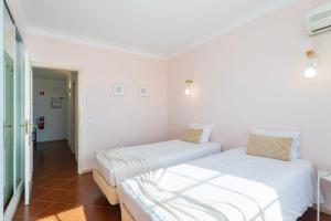 TAC - Serene Shores - Portimão في Vau: سريرين في غرفة بجدران بيضاء