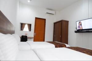 Кровать или кровати в номере Hotel Netral Jombang