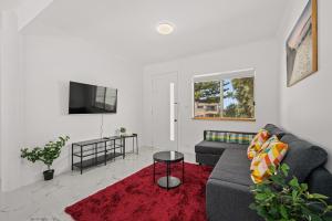 a living room with a couch and a tv at Moana Ocean - C21 SouthCoast Holidays in Moana
