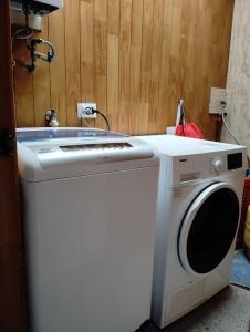 une laveuse et une sécheuse dans une pièce dans l'établissement Acogedora casa en el sur de Chile, ubicada en barrio residencial, à Puerto Montt 1 autre photo
