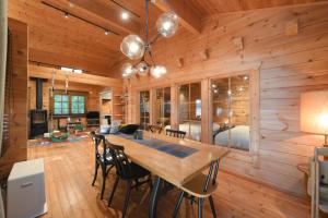 a wooden dining room with a table and chairs at あそびのコテージ廿日市 in Tomota