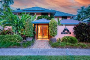 una casa rosa con una puerta naranja en Villa 3 @ Chez Willow, 2 mins to Four Mile Beach, en Port Douglas