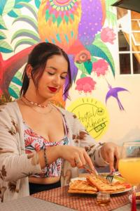 a woman sitting at a table with a plate of food at Hostal Colombian Gold in San Gil