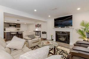 a living room with white furniture and a fireplace at Luxury Basement Apartment in Oakville in Oakville