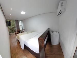 a small bedroom with a bed and a window at Econtainer Suítes Macacos in Macacos