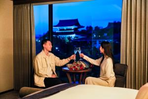 a man and woman sitting in a hotel room with a glass of wine at Hotel Okura Kyoto Okazaki Bettei -Age Requirement 12 over- in Kyoto