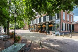 een straat met tafels en stoelen voor een gebouw bij Hotel Cafe Restaurant De Gouden Karper in Hummelo