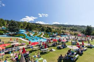 a large crowd of people sitting in the grass at a water park at Ultimate Relaxation Heritage Charmer in Vernon