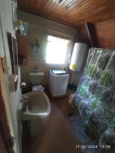 uma pequena casa de banho com lavatório e WC em Casa en Liquiñe em Liquiñe