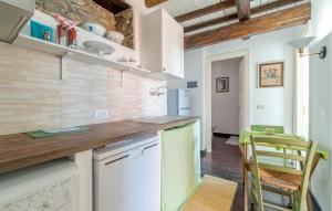 a kitchen with white appliances and a table and chairs at Stunning Apartment In Recco With Outdoor Swimming Pool, 1 Bedrooms And Wifi in Recco