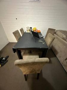 a black table with chairs and a laptop on it at Ozone point in Perth