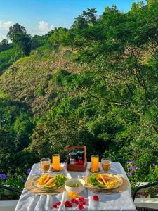 stół z dwoma talerzami jedzenia i soku pomarańczowego w obiekcie Above the clouds - Doi mae mon 