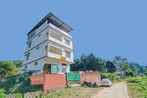 een gebouw op een heuvel naast een onverharde weg bij OYO Shirdi Sai Guest House in Kamakhya