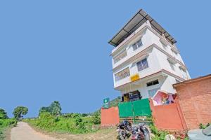 un edificio en una colina al lado de un camino de tierra en OYO Shirdi Sai Guest House, en Kamakhya