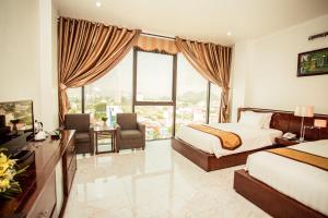 a hotel room with a bed and a desk and chair at Royal Hotel Ninh Bình in Ninh Binh