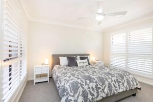 Un dormitorio blanco con una cama y dos mesitas de noche. en 13 Cavill Avenue, en Forster 7 fotos más