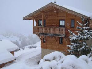 a log cabin with a deck in the snow at Chalet Vars, 6 pièces, 12 personnes - FR-1-773-13 in Vars