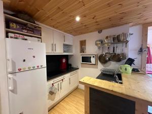 a kitchen with white cabinets and a white refrigerator at Appartement Vars, 3 pièces, 8 personnes - FR-1-773-14 in Vars