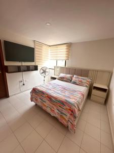 a bedroom with a bed and a flat screen tv at A metros de las playas de Bello Horizonte y de Centro Comercial Zazue in Santa Marta +11 photos