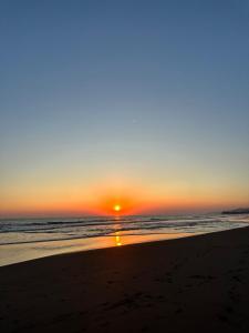 a sunset on a beach with the ocean at Surf City Town House in La Libertad