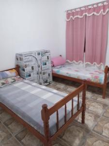 a room with two beds and boxes in it at Pousada do vovô in Rio das Ostras