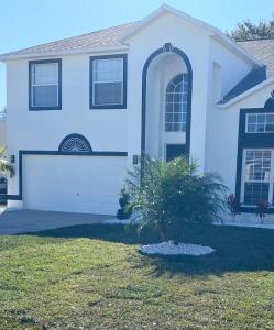 a blue house with a palm tree in the front yard at Magical Vacation Stay in Davenport