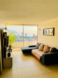 uma sala de estar com um sofá e uma grande janela em Departamento con espectacular Ubicación, Vista al Mar y Panorámica a todo Iquique em Iquique