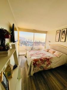a bedroom with a bed and a large window at Departamento con espectacular Ubicación, Vista al Mar y Panorámica a todo Iquique in Iquique
